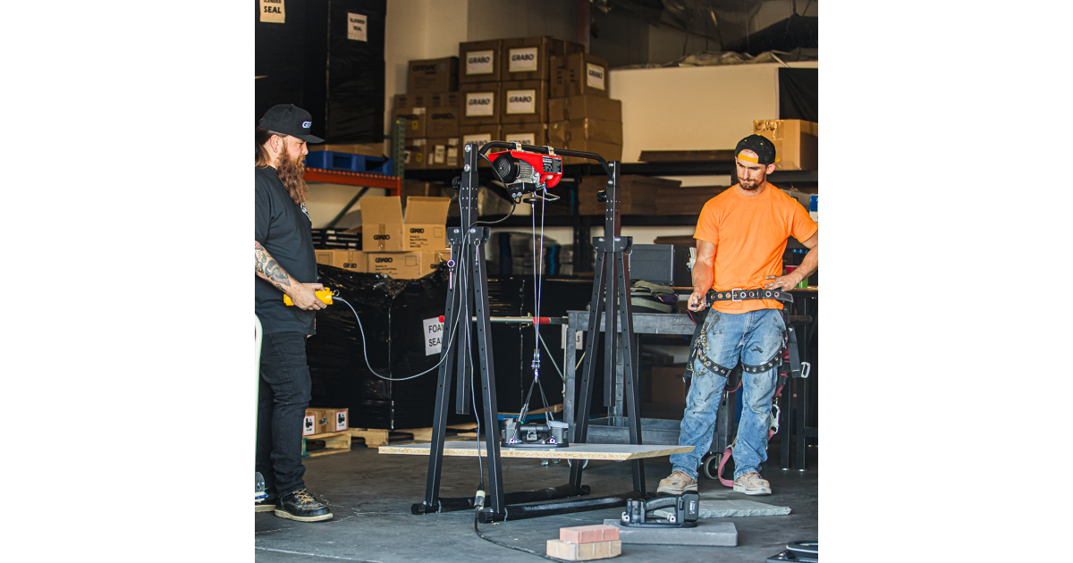 Two men working with a GRABO lifter in an industrial setting