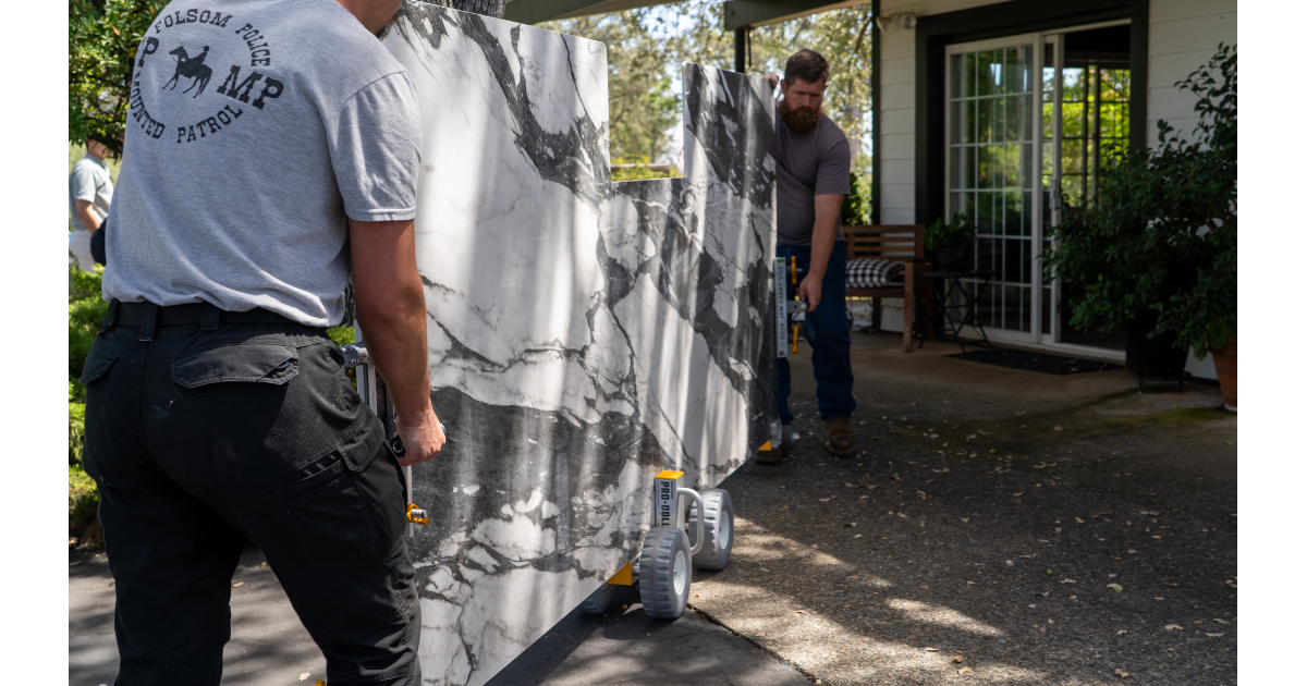 Omni Cubed Pro Dolly HD3 - 2 men moving large piece of Quartzite on dolly towards door opening of home