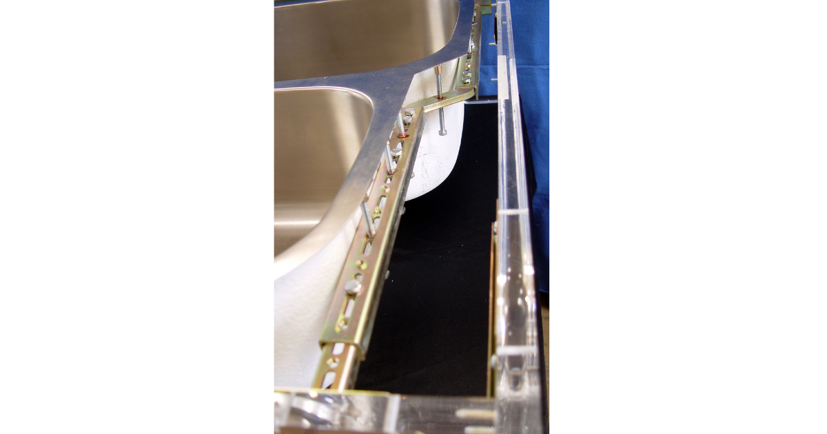 Back side length view of Sink Setter PW-114-P showing curved adjustable bracket, bolts and screws and sink in place
